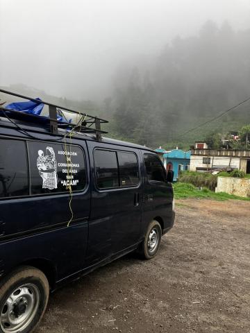 Photo of a van with the ACAM logo on it parked in front of mist-covered trees