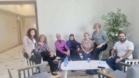 A group photo of Katrina and several other women sitting around a white coffee table