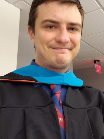 Selfie of Robert Brehm wearing his LBJ School graduation robes