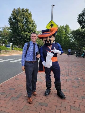 Robert Brehm stands with the UVA mascot. 