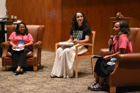 Speakers sitting at the front of the classroom, speaking into a microphone