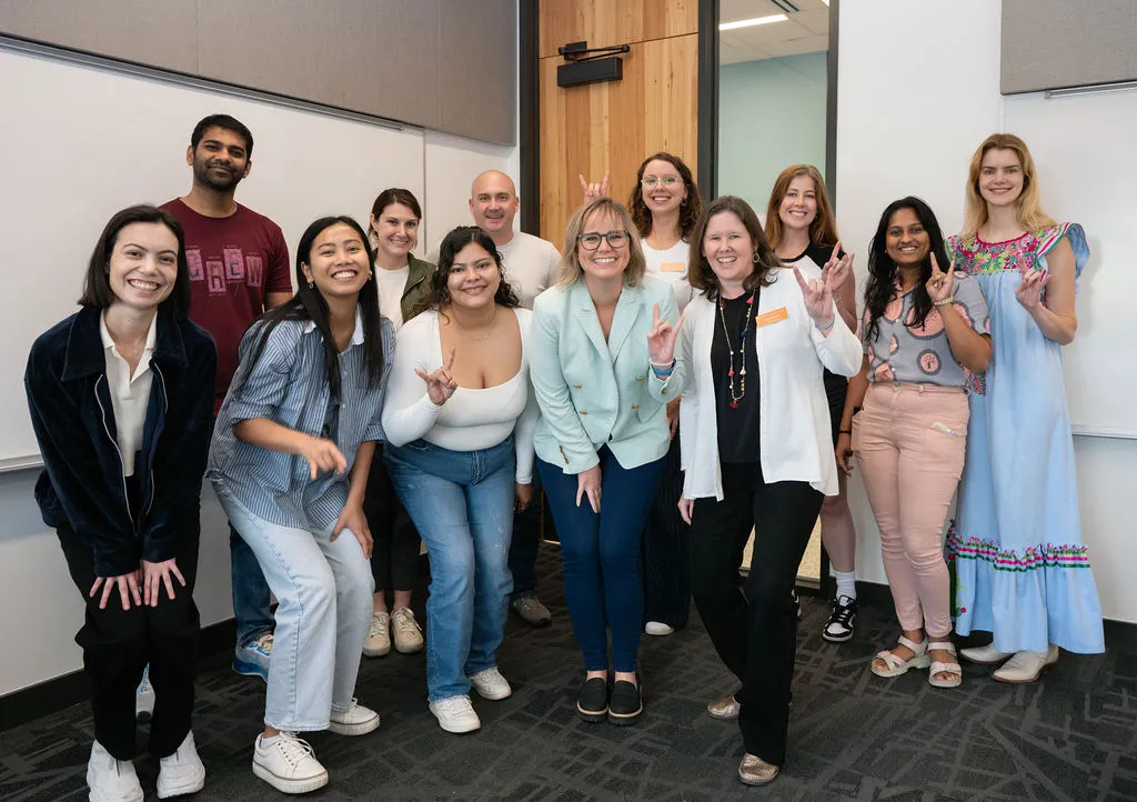 Group of students smiling at the camera with guest alum speaker