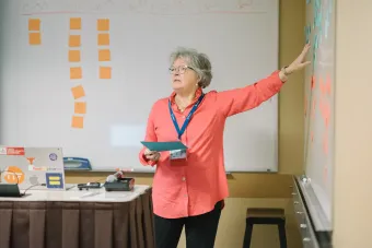 Professor Sarah Jane Rehnborg leading a discussion, pointing to a whiteboard