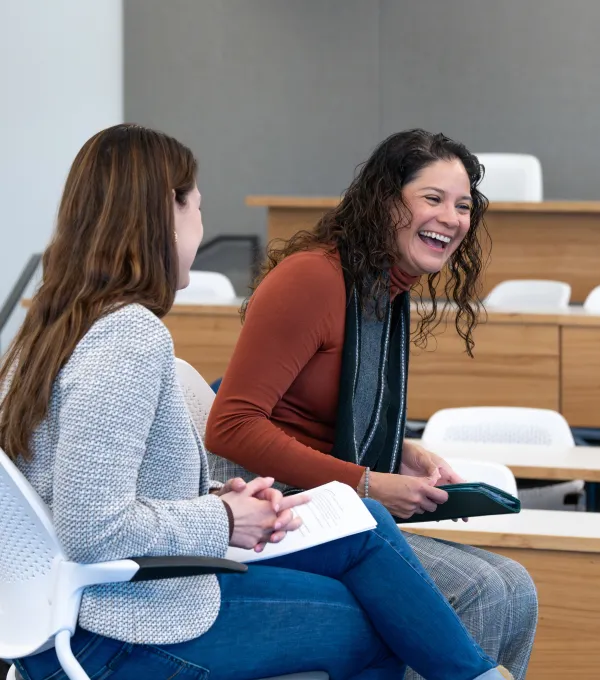 Alumni guest speaker laughs while talking with student moderator