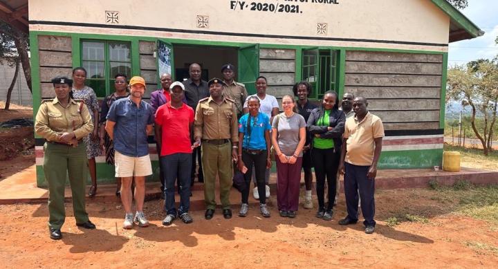 Group photo, including UT Austin faculty and students, standing in front of the Office of the ACC in Kenya