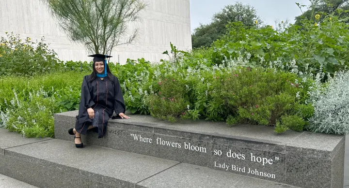 Fernanda in cap and gown outside of LBJ.